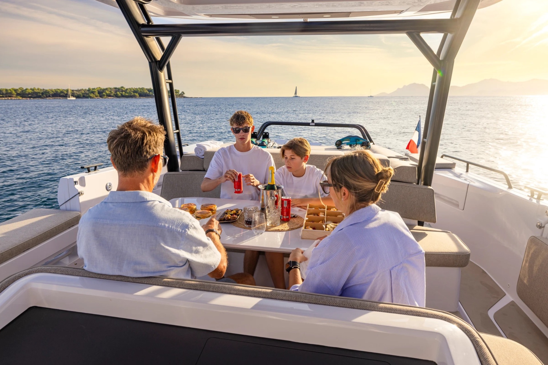 Family dining on the aft deck of the Axopar 45 at sunset